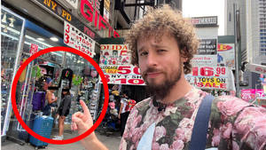 男人指著兩個在繁忙城市街道上購買紀念品的女士。
