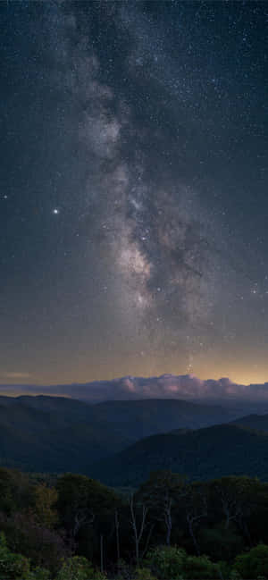 夜晚山脈和森林上空的銀河系