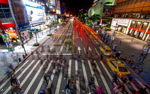 夜間城市街道，帶有模糊的行人和車燈軌跡。