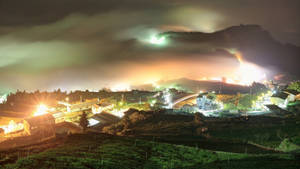 一個舒適的山村夜景，燈光閃爍，山巒霧繞。 — 夜晚 GIF 壁紙