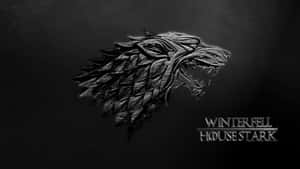 金屬狼頭標誌，在深色背景上帶有「Winterfell House Stark」文字。 — 銀色 壁紙