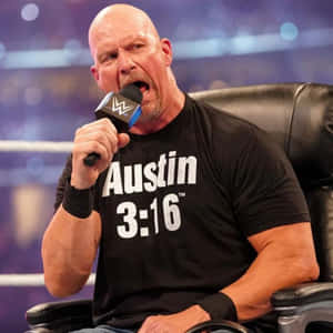 摔角手 Austin 3:16 坐在擂台內的椅子上，對著 WWE 麥克風大喊。