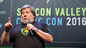 男士在Comic-Con Valley 2016活動中手持麥克風並指向上方發言。