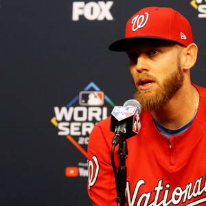 穿著紅色國民隊球衣的棒球運動員在MLB世界大賽新聞發布會上講話。