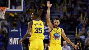 兩名身穿黃色球衣的NBA籃球運動員高舉雙手慶祝一次進攻。