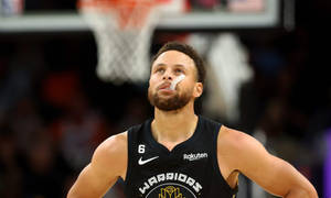 戴著鼻貼的職業籃球運動員在比賽中向上看。 — 卡通史提芬居里 壁紙