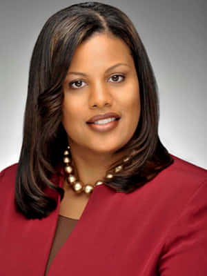 專業女性身穿紅色西裝外套和金色珍珠項鍊，對著鏡頭微笑。