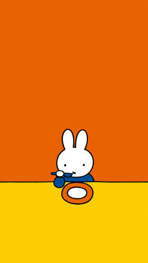 穿著藍色襯衫的白兔在黃色表面上從橙色碗中進食。 — 白兔 壁紙