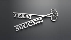 一把金屬鑰匙，形狀為 'TEAM SUCCESS' 字樣，置於深灰色表面上。