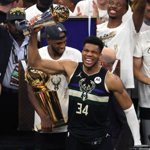 籃球運動員手持NBA總冠軍獎盃，隊友們慶祝。