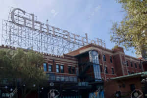 Ghirardelli 標誌在磚建築頂部，伴隨著樹木和藍天