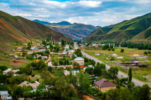 一個位於山谷中的小村莊，有綠色山丘和蜿蜒的道路。