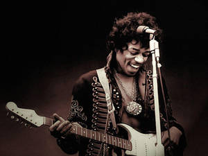 Jimi Hendrix 在舞台上彈奏電結他，表情愉快。