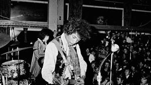 Bob Dylan 在1960年代的音樂會上，拿著結他在觀眾面前現場表演。