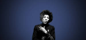Jimi Hendrix 在藍色背景的攝影棚肖像中抽煙。