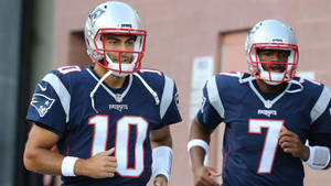 兩名NFL美式足球員在練習時穿著愛國者隊制服慢跑。