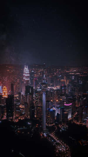 夜晚的吉隆坡城市景觀，燈光璀璨的塔樓和星空。 — 夜晚 GIF 壁紙