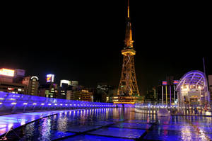 東京鐵塔在夜晚閃耀，藍色水景倒映和城市燈光。 — 夜景城市 壁紙