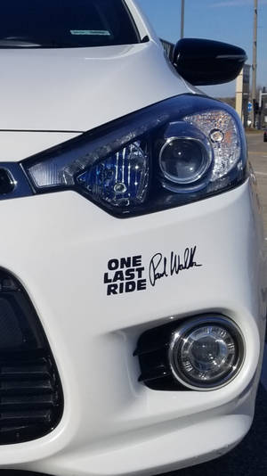 白色車保險桿上貼有「One Last Ride」貼紙及保羅·獲加簽名。