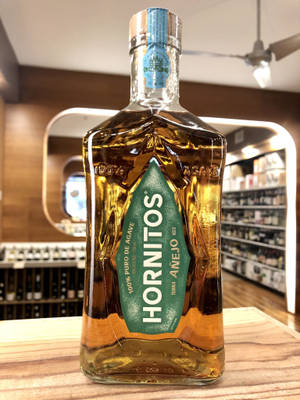 酒舖木質櫃檯上的一瓶Hornitos Añejo龍舌蘭酒。