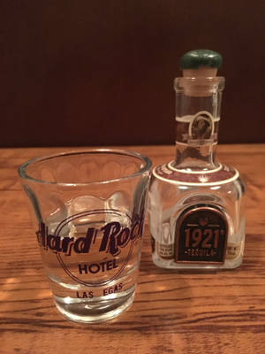 Hard Rock Hotel Las Vegas烈酒杯旁邊有一瓶1921龍舌蘭酒在木頭上。
