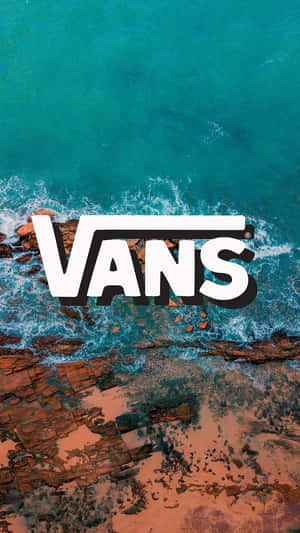 從上方俯瞰，Vans標誌疊加在拍打紅色岩石的海浪上。