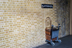 火車站Platform 9¾標誌下，復古行李車上堆疊的皮箱。