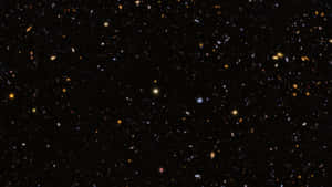 深空充滿遙遠的星系和恆星，背景為黑色。