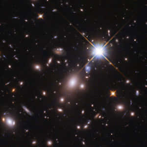 深空視圖，顯示星系和明亮的星星，帶有鏡頭光暈效果。 — 太空 壁紙