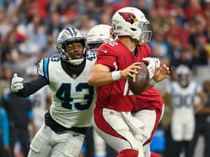 NFL四分衛在防守球員的壓力下傳球。