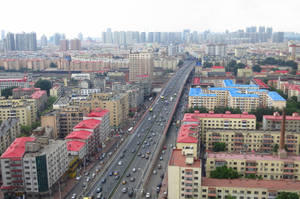 鳥瞰繁忙的城市，有高速公路和公寓樓，天空多雲。 — 唐人街 GIF 壁紙