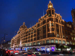 Harrods 百貨公司在夜晚以節日燈光和模糊的交通照亮。 — 夜景城市 壁紙