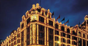 Harrods 百貨公司在夜晚被金色燈光和旗幟照亮。 — 美學 壁紙