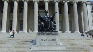 黑色Alma Mater雕像在古典建築前的石階上，附近有人。