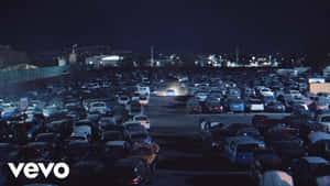 擁擠停車場的夜景，停放的車輛和遠處的工業燈光。