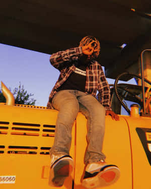 黃昏時分，天橋下，人坐在黃色工程車上