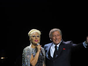 Lady Gaga 和 Tony Bennett 在表演期間於舞台上微笑。