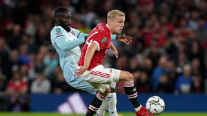 兩名足球運動員在夜間體育場爭奪球權。