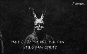 一個戴著兔面具的可怕人物，文字問為什麼有人穿著愚蠢的男人西裝。