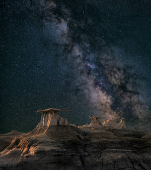 夜晚沙漠岩石層上的銀河系 — 星星 壁紙