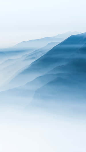 柔和藍色調的霧中山脈，層疊的山峰逐漸消失在薄霧中。