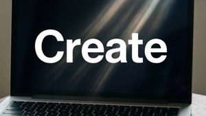 筆記型電腦螢幕顯示「Create」一詞，背景有光條。 — MacBook 壁紙