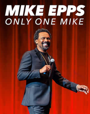 喜劇演員 Mike Epps 喺舞台上手持咪高峰微笑。 — 4:5 壁紙