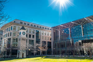 現代大學建築與鐘樓，在明亮陽光和光禿樹木下