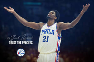 Joel Embiid 身穿白色球衣，高舉雙臂慶祝，帶有「Trust The Process」文字。