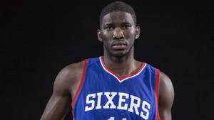 身穿Sixers球衣的職業籃球運動員專注地看著鏡頭。