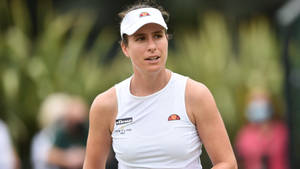 女網球運動員穿著白色運動裝備在球場上，背景為綠色。 — 網球 壁紙