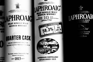 Laphroaig 威士忌酒瓶特寫，帶有粗體文字和復古蒸餾廠插圖。