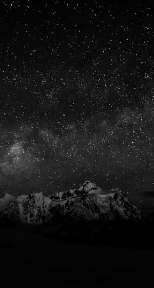 在可見銀河的星空下，積雪的山峰。 — 暮光 壁紙
