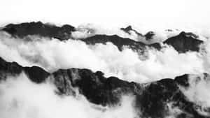 黑白山脈從高海拔的雲層中浮現。 — 天際線 壁紙